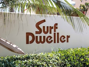 Un cartello con la scritta 'Surf Dweller' in un carattere sans-serif marcato.