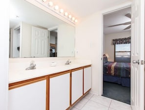 A bathroom with a large mirror, two sinks, and a vanity. - Emerald Twrs West 3003 by Brooks and Shorey Resorts (Fort Walton Beach)