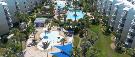 Un complejo turístico con varias edificaciones, una zona de piscina central y abundante vegetación circundante.