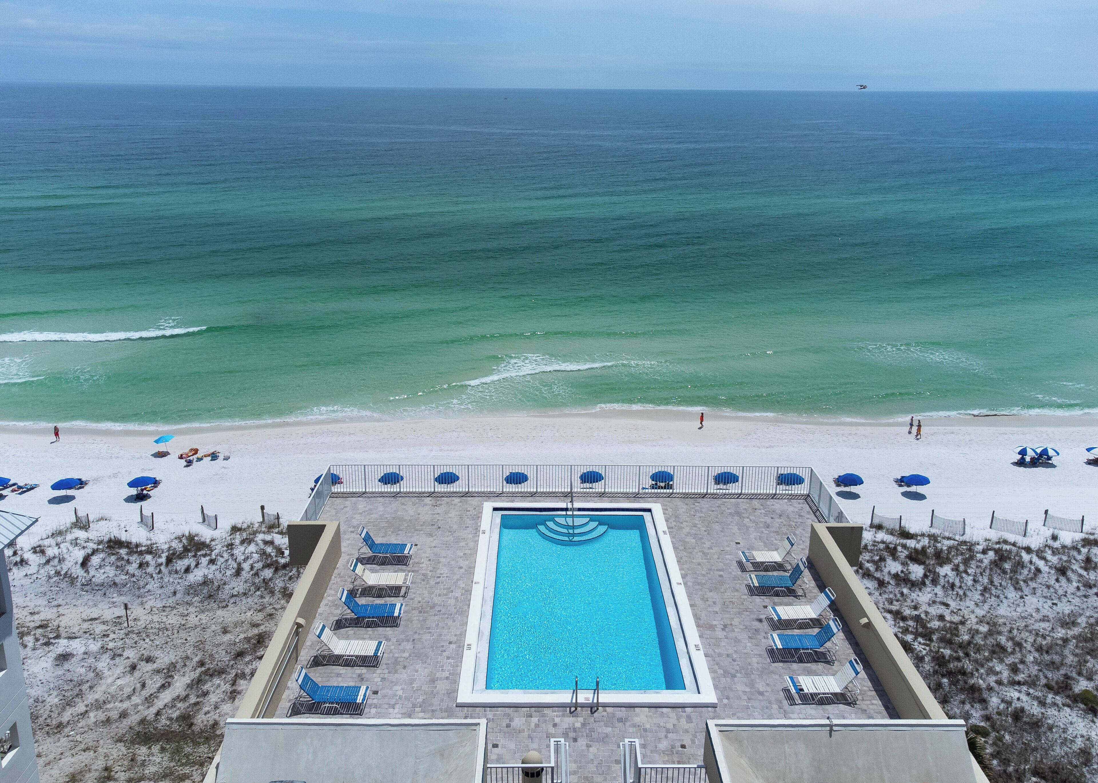 A pool with a view of the beach and ocean.