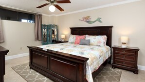 A bedroom with a large bed, a dresser, a nightstand, a ceiling fan, and a window with curtains. - Gulfside 302 - Ocean Serenity (Fort Walton Beach)