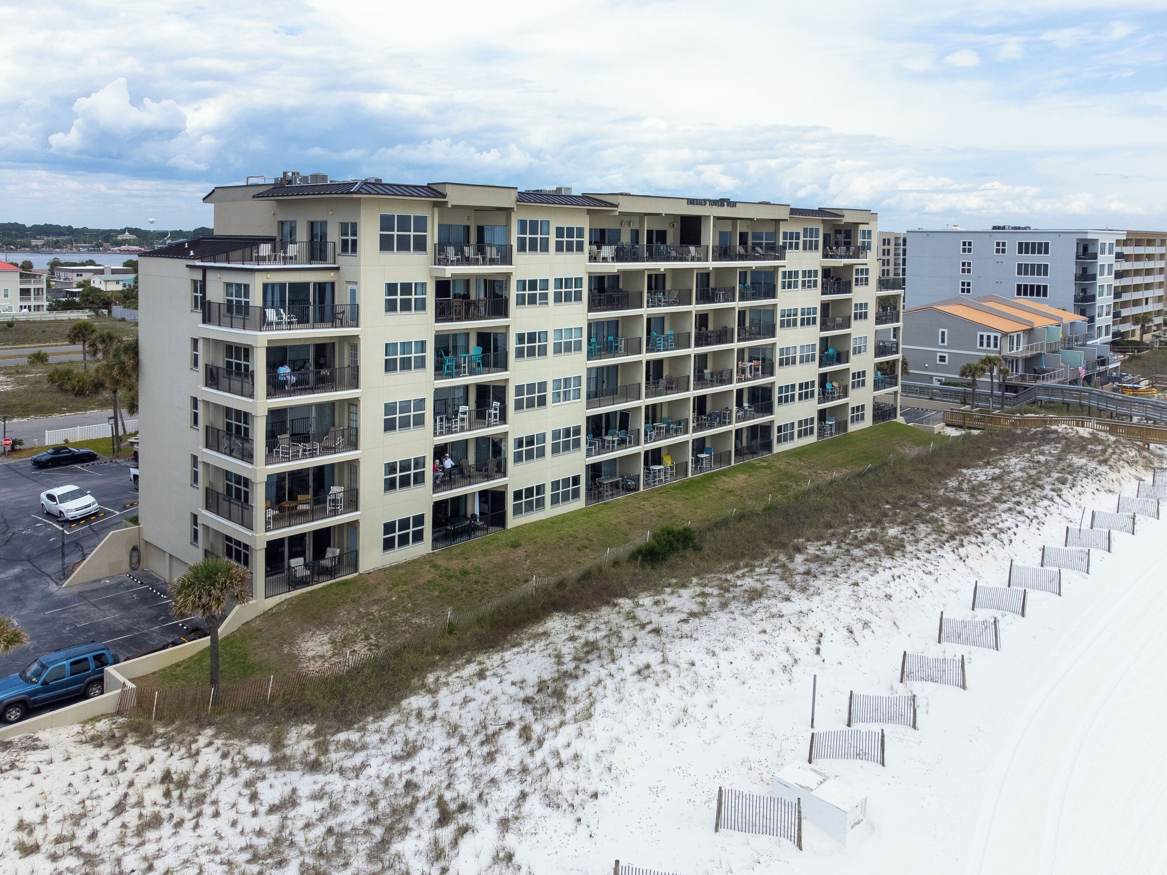 Un hôtel à plusieurs étages doté de balcons, d’un parking et situé en bord de mer.
