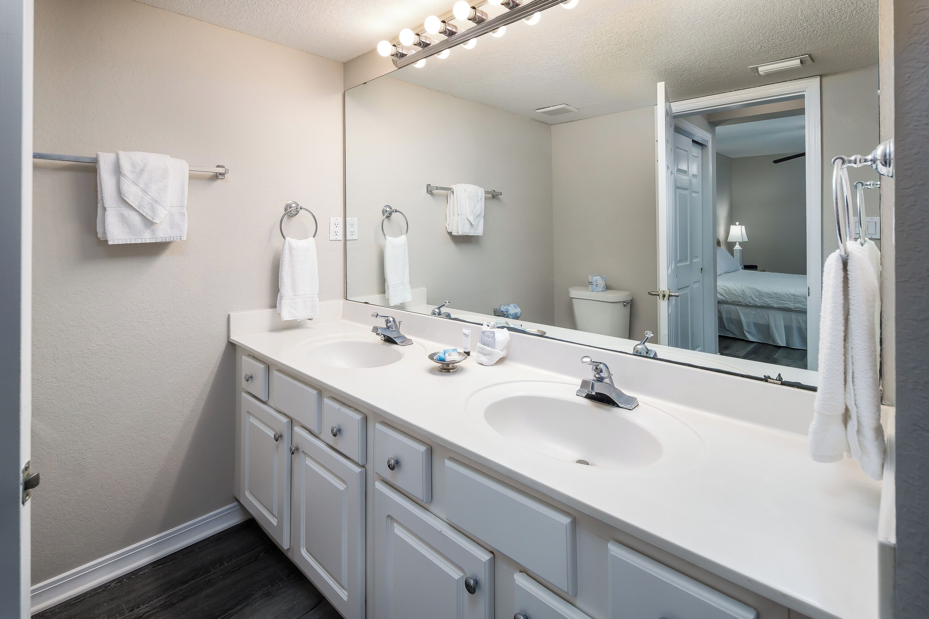 A modern bathroom with two sinks, a large mirror, and a walk-in shower.