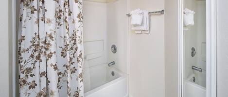 A bathroom with a shower, a bathtub, and a toilet.