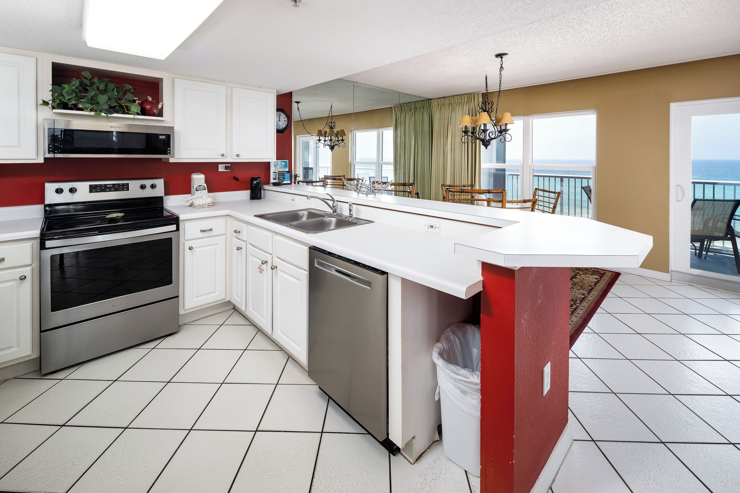 A modern kitchen with white cabinets, stainless steel appliances, and a large island.