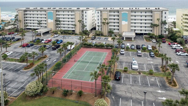 A hotel with multiple floors, a parking lot, and a tennis court. - Gulf Dunes 504 - Emerald Sea Oasis (Fort Walton Beach)