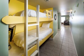 Ein Zimmer mit Etagenbetten, einem Schreibtisch und einem Stuhl.