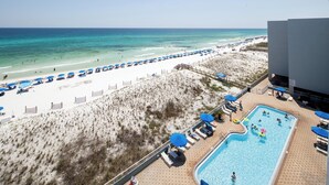 Ein Hotel direkt am Strand mit Schwimmbad, Sonnenschirmen und einem Sandstrand.