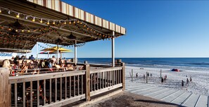 Ein Restaurant direkt am Strand mit Außenbereich und Meerblick.