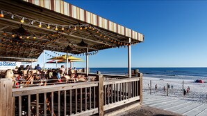 Un restaurante frente a la playa con terraza y vistas al océano.