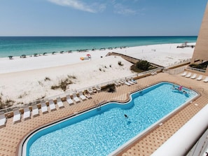 A swimming pool with a view of a beach and ocean. - Islander 7010 - Coastal Charm (Fort Walton Beach)