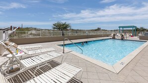 Una piscina con lettini e una zona coperta.