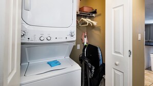 A laundry area with a washing machine, a drying rack, and a door to a bathroom. - Island Princess 309 - Splash of Paradise (Fort Walton Beach)