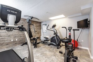 A home gym with various exercise equipment including a treadmill, stationary bike, and elliptical machine. - Gulf Dunes 416 - Ocean's Edge (Fort Walton Beach)