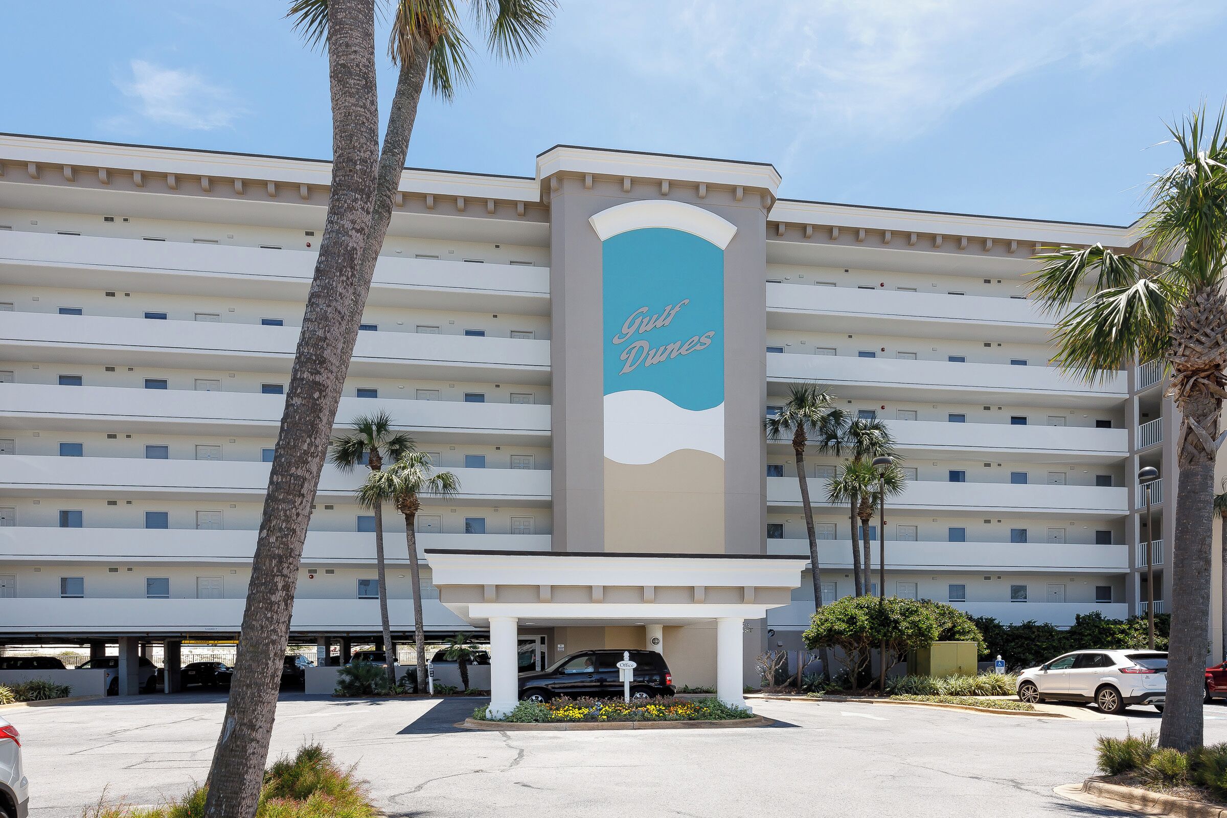 A multi-story hotel with a prominent sign reading "Gulf Dunes."