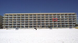 Ein mehrstöckiges Hotel mit Balkonen in Strandnähe.