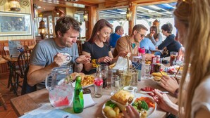 A restaurant with wooden interiors, tables with various dishes, and a menu.