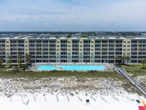 Ein Hotel mit großem Pool, mehreren Balkonen und Strandbereich.