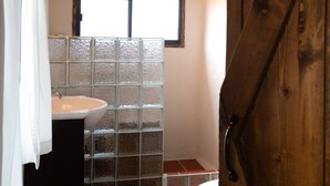 A bathroom with a wooden ceiling, a window, a sink, and a toilet. - Mimi's Bunkroom - just outside of Big Bend Nt'l Park (Terlingua)