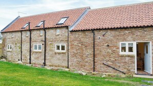 A brick building with a red-tiled roof, multiple windows, and a door. - 4 bedroom accommodation in Driffield, near Bridlington (Driffield, near Bridlington)