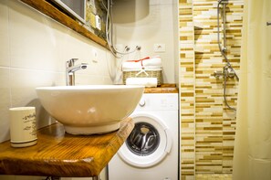 A bathroom with a large white sink, a washing machine, and a shower area. - Apartament "Pomigranaj" for 4 person (Marezige)