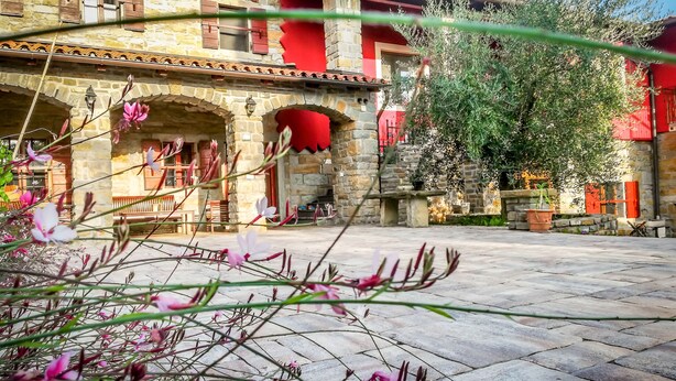 A courtyard with stone buildings, red shutters, and a bench. - Apartament "Pomigranaj"  for 4 person (Marezige)
