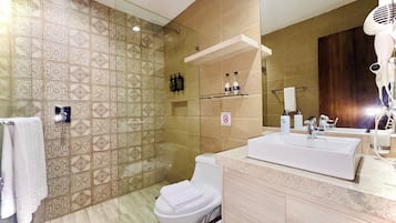 Un baño con baldosas estampadas, un lavamanos blanco y una zona de ducha.