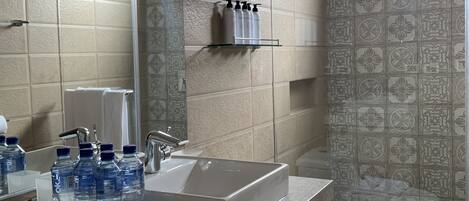 Une salle de bain moderne avec un grand lavabo, un miroir et un espace douche.