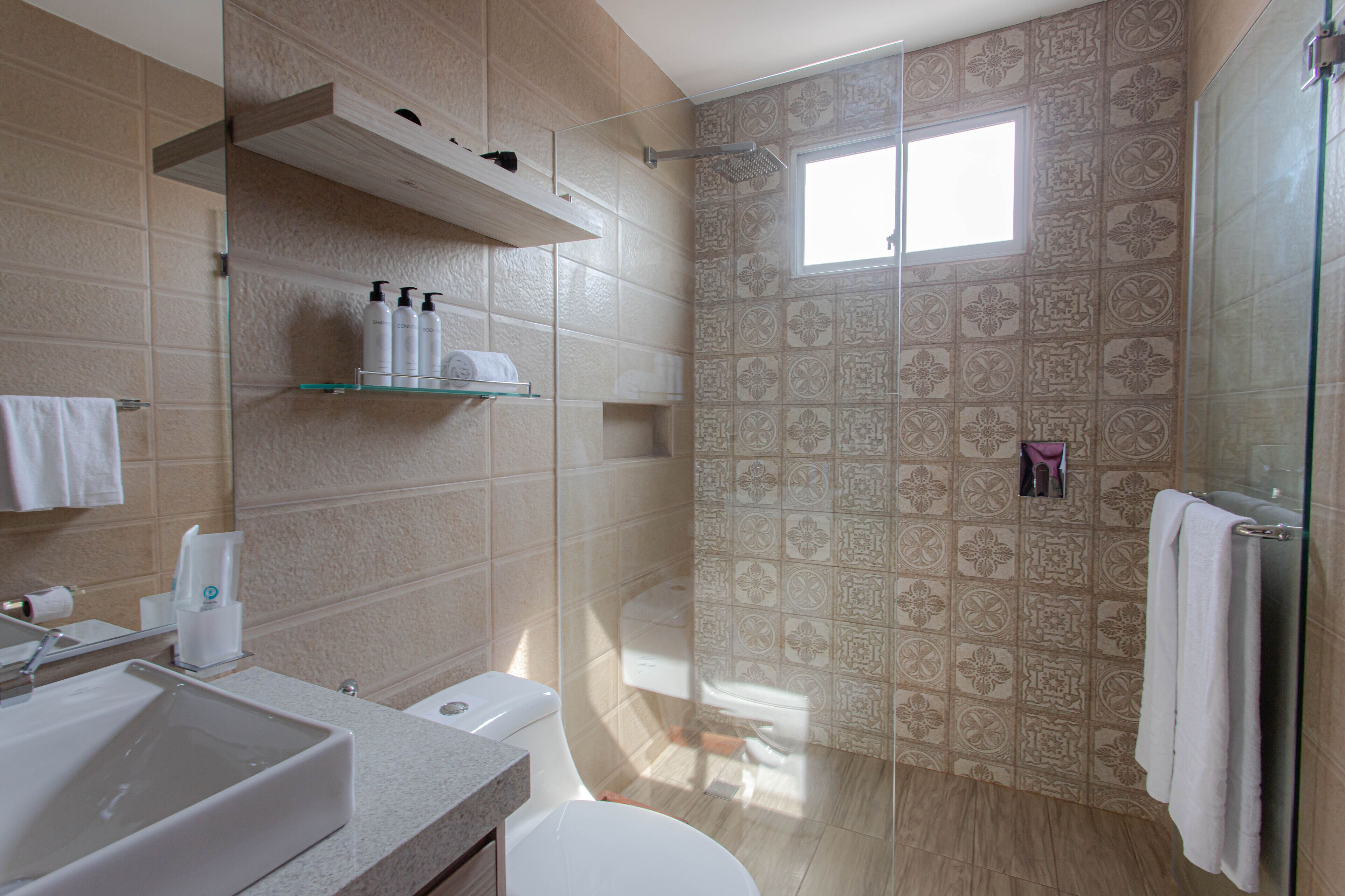 A modern bathroom with a large sink, toilet, and shower area.