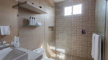 A modern bathroom with a large sink, toilet, and shower area.