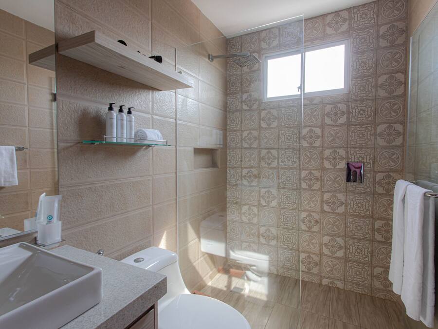 A modern bathroom with a large sink, toilet, and shower area.