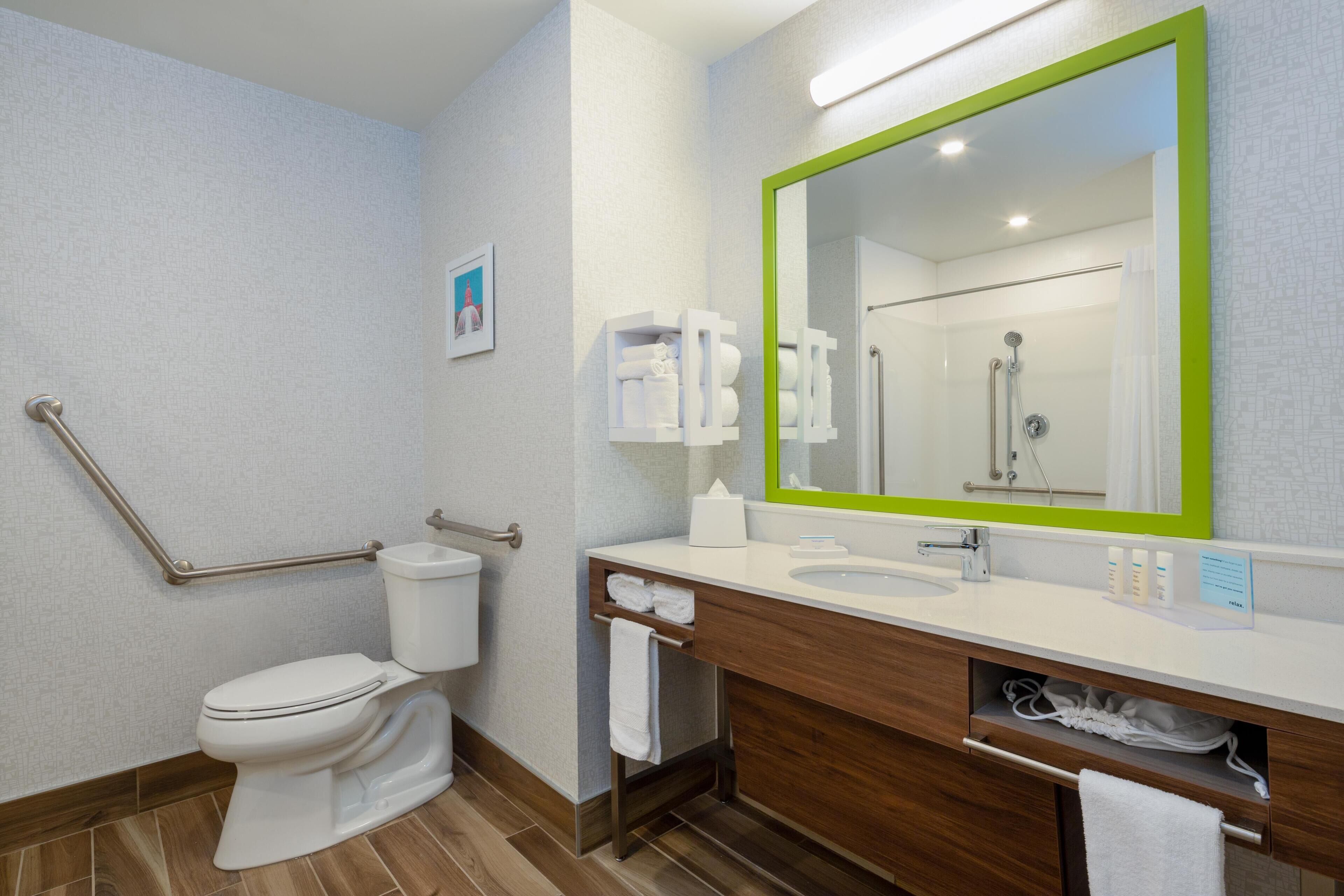 A modern bathroom with a toilet, sink, and mirror.