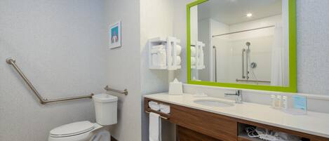 A modern bathroom with a toilet, sink, and mirror.