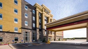 Un hotel de varios pisos con fachada de piedra y exterior amarillo y marrón.