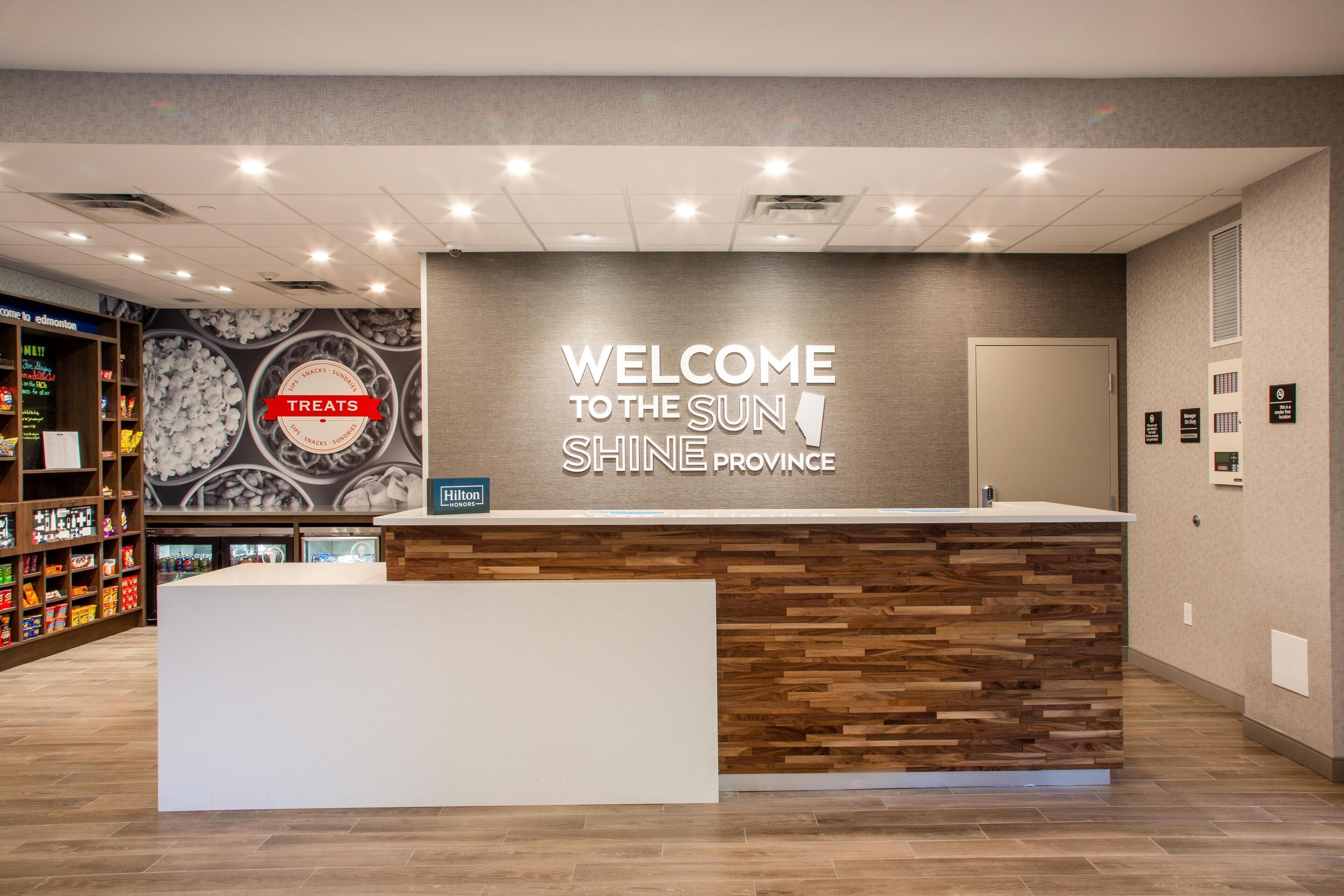 A reception area with a sign reading "Welcome to the Sun Shine Province" and a counter.