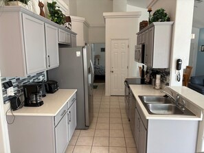 A modern kitchen with white cabinetry, a refrigerator, a coffee maker, and a microwave. - Superb Lakeside villa (Clermont)