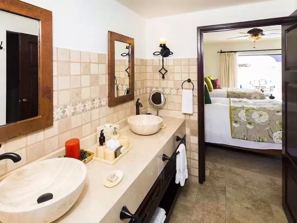 A bathroom with a large sink, a mirror, a wall-mounted light, and a towel rack.