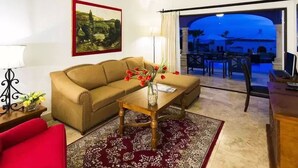 A living room with a sofa, coffee table, and a view of the outside.