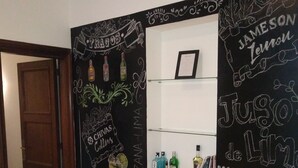 Un muro con decorazioni a lavagna che includono 'TRAGOS', 'MANZANA', 'JUSO', 'BEEFETTER' e 'tonic'.