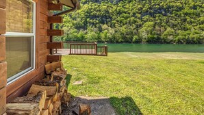 A cabin with a deck overlooking a lake and forested hills. - The Lower Deck on Riverview ~ direct river access (Mountain View)