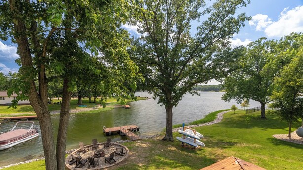 Vista sul lago con molo, tavolo da picnic e zona relax all'aperto.