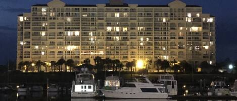 Un hotel grande con varios pisos y balcones, reflejado en el agua.