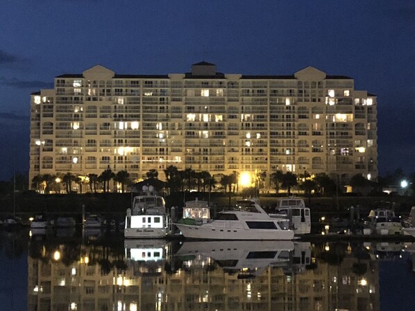 A large hotel with multiple floors and balconies, reflecting in the water.