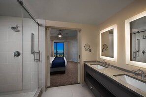 Een bad/douchecombinatie, een bubbelbad, handdoeken, toiletpapier