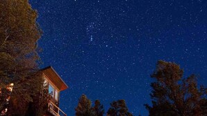 Une cabine dotée d’un balcon donnant sur un ciel nocturne étoilé.