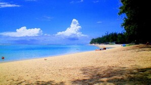 A beach with clear blue water, sandy shore, and a few people relaxing. - La Kazanou (Saint-Joseph)