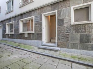 Stylish building with a textured facade, featuring large windows and a central entrance.