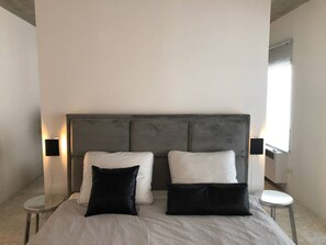 Relax in a serene bedroom with a large bed, two bedside tables, and a minimalist design.