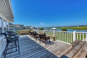 A wooden deck with outdoor furniture and a view of a body of water. - Miller Villa, 6 bedroom, 3 bathrooms, deep water channel (Murrells Inlet)