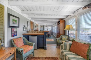A spacious kitchen with a central island, dining area, and seating with a view. - Miller Villa, 6 bedroom, 3 bathrooms, deep water channel (Murrells Inlet)